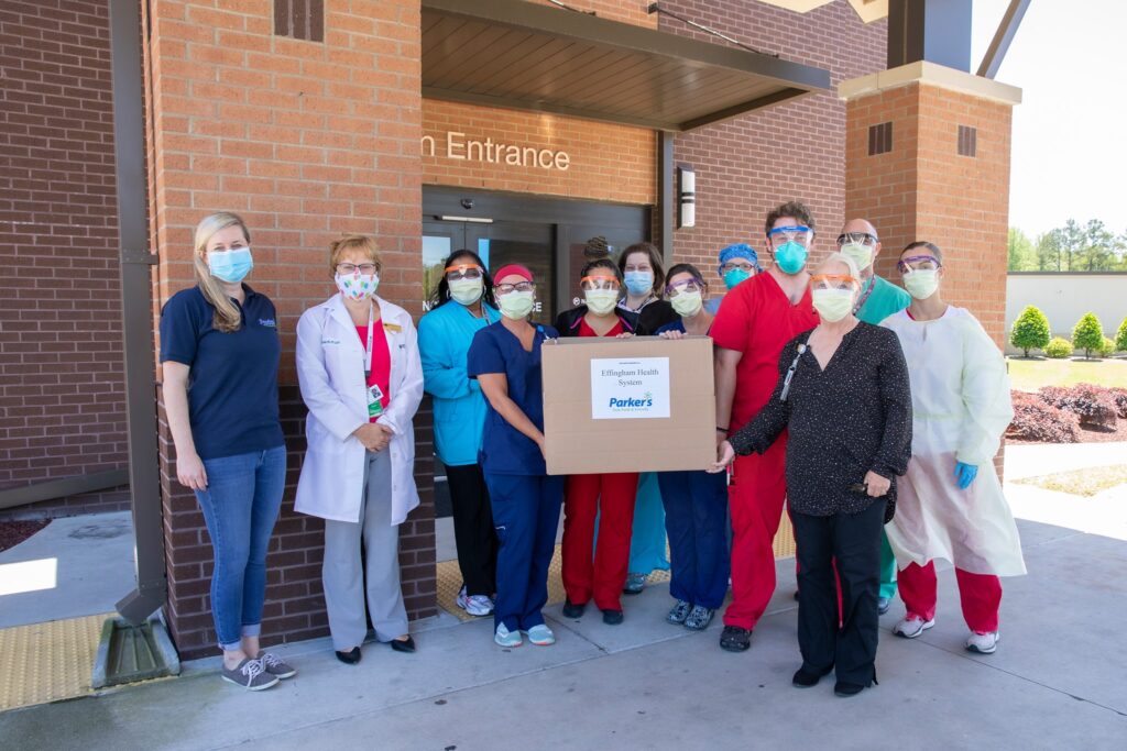 EHS emploees holding a box of donated supplies